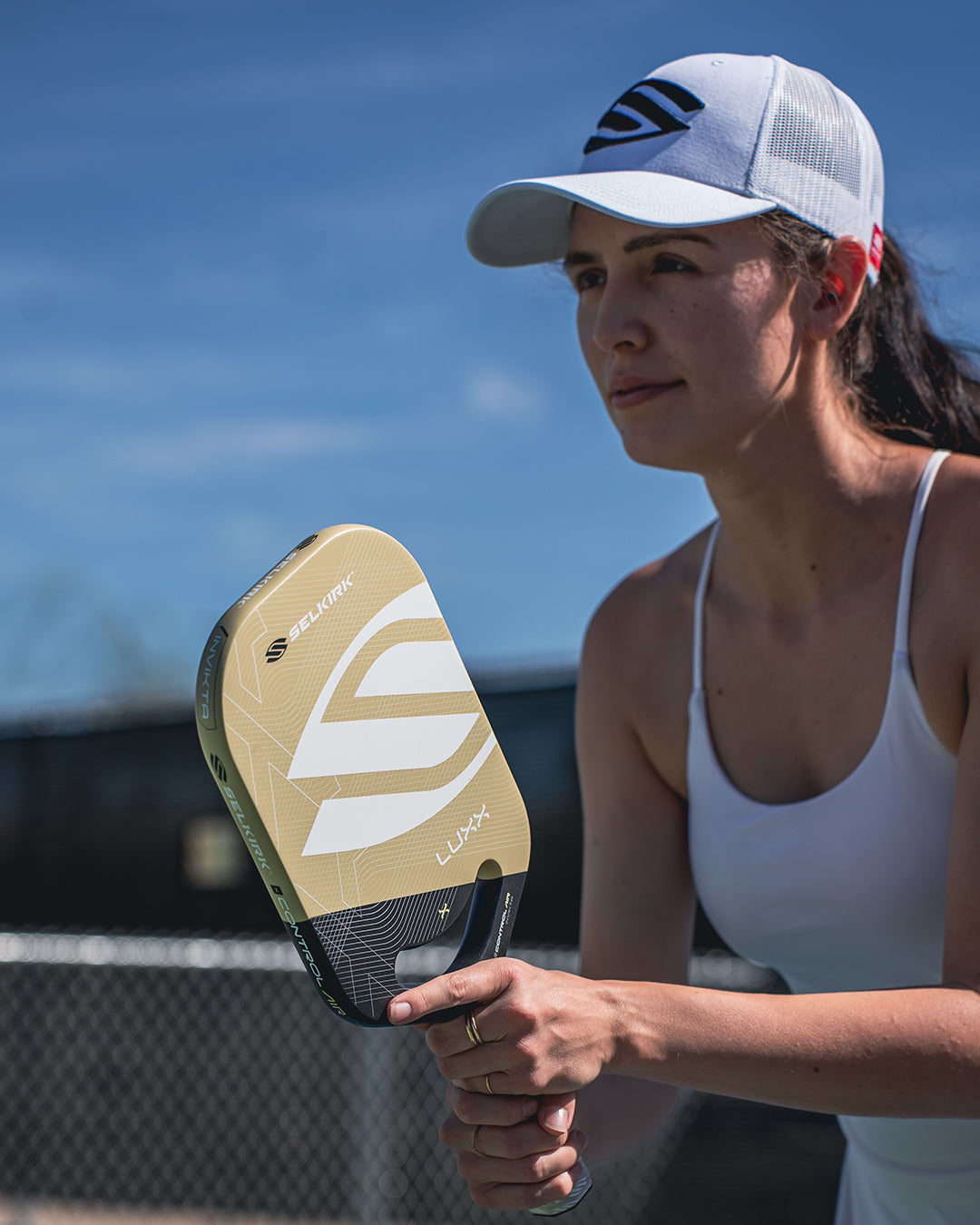 A woman holding a Selkirk LUXX Control Air Invikta pickleball paddle with Aero-DuraEdge Edgeless Technology